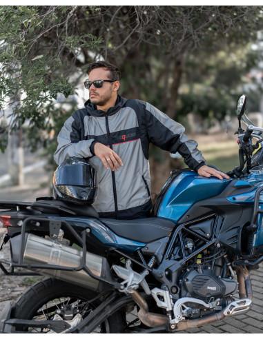 Motociclista con chaqueta reflectiva junto a su moto